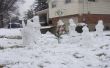 Familia de nieve con perro, árbol de Navidad y regalos